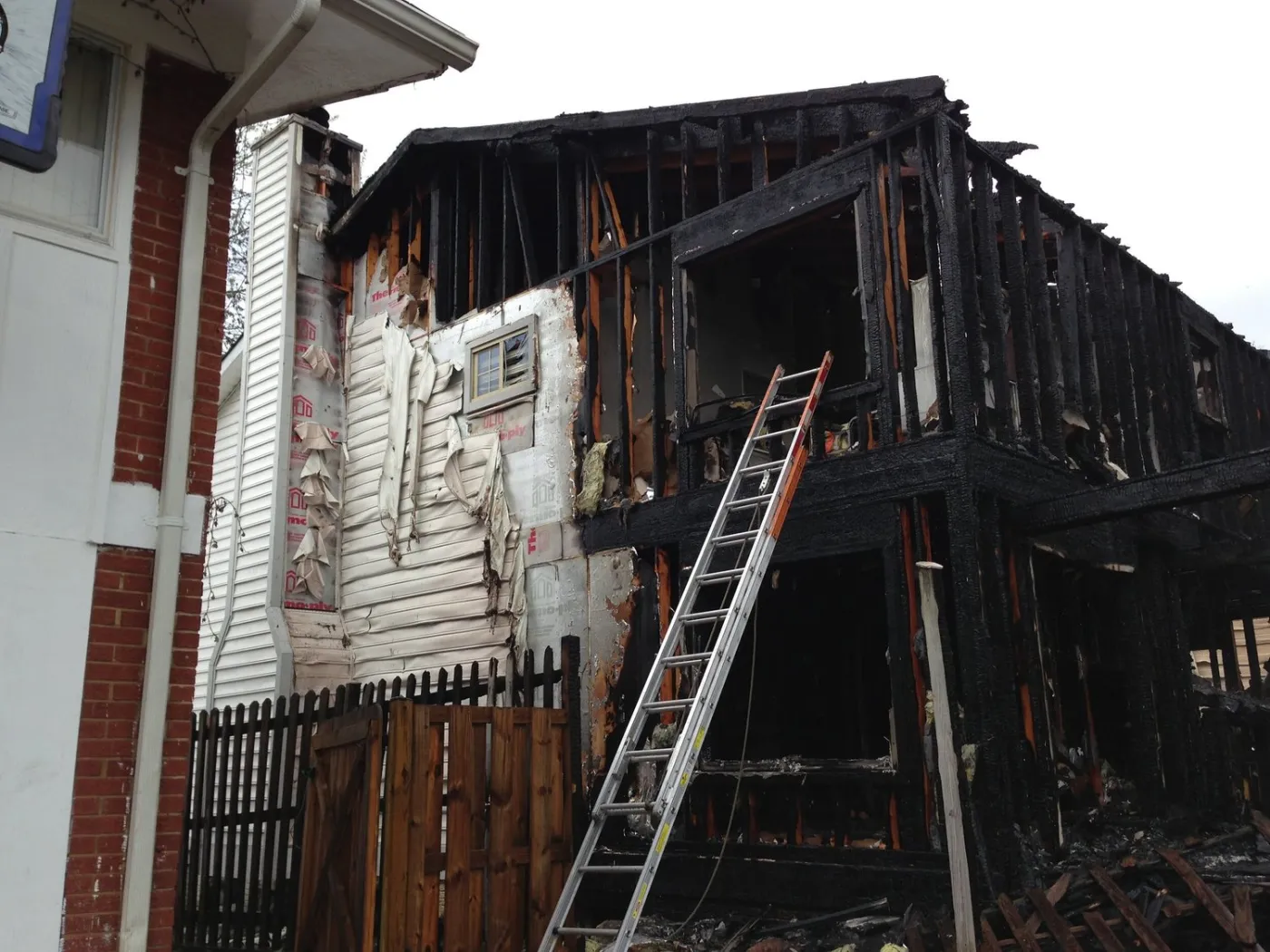 The side of the burned house, with a ladder against it