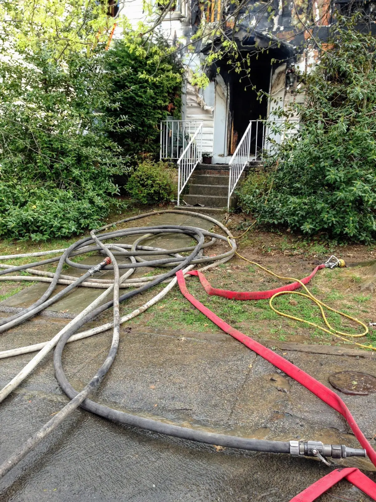 Fire hoses tangled across the ground after a fire